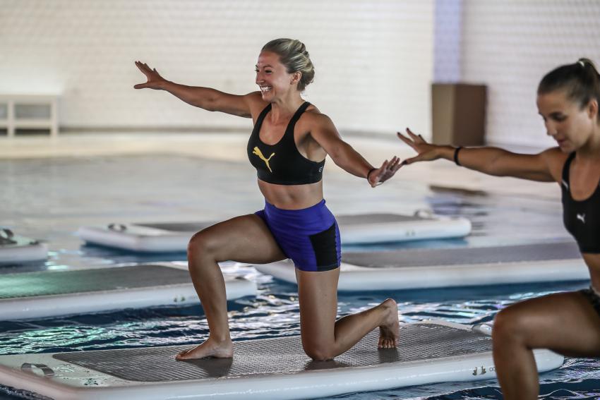 vrouw op aquabase mat in zwembad
