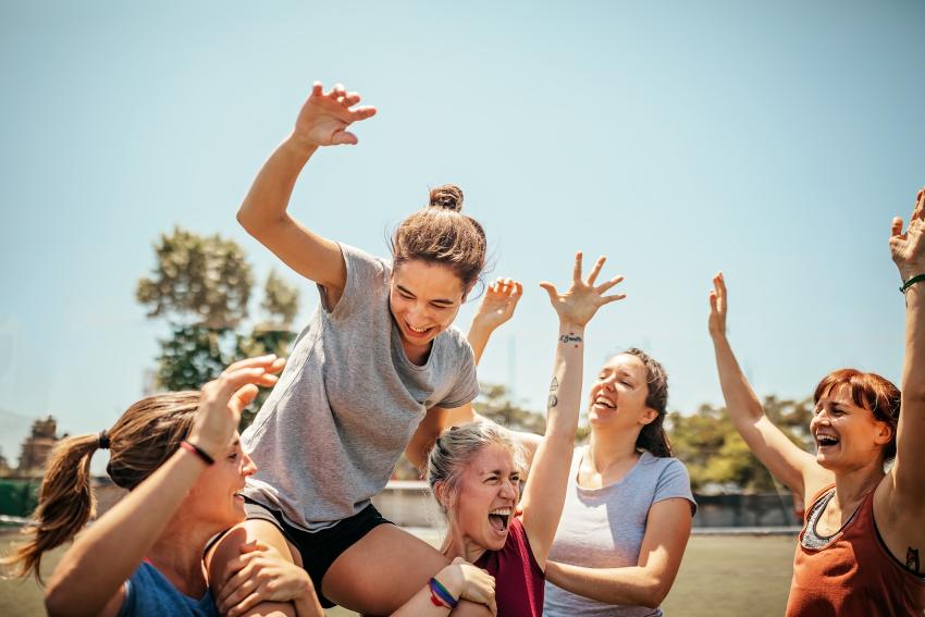 Vrouw die door een groep in de lucht wordt gehouden