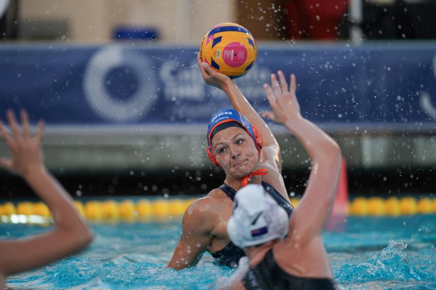 Vrouw die haar hand bij de bal heeft tijdens waterpolo