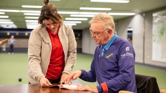 Mynt en sportregisseur Marly die naar Kies je Sport boekje kijken, klik voor een vergroting