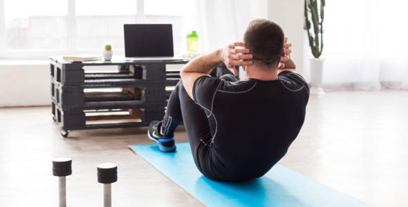 Man sport in zijn woonkamer