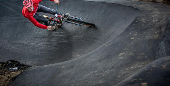 Man op BMX fietst in pumptrackbaan in het Urban Sportpark