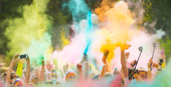 Mensen die tijdens een colorrun met kleurpoeder gooien