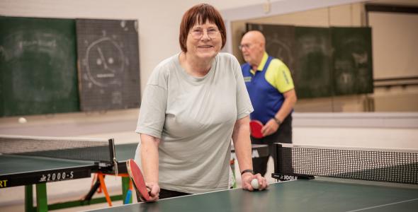 Tafeltennisster Josée aan een tafeltennistafel met op de achtergrond man die ook aan het spelen is
