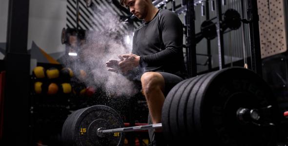 Sporter die een gewicht gaat heffen