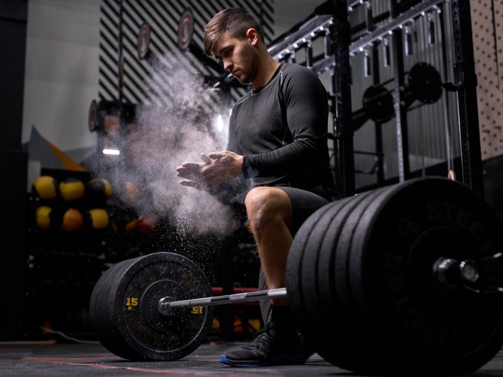 Sporter die een gewicht gaat heffen